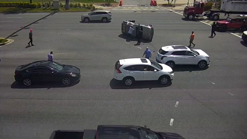 Watch good Samaritans rush into a busy intersection after driver flips vehicle [Video]
